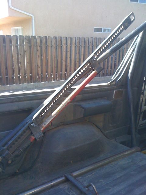 1990 Ford Bronco - Hi-lift jack mounted in the rear of a vehicle, possibly for off-road use.