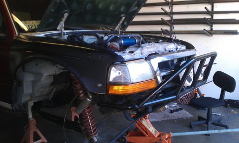 1992 Ford Ranger - Front end of a 1992 Ford Ranger undergoing modifications, with the hood up and custom bumper installed.