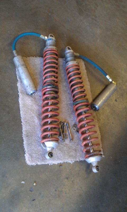 1992 Ford Ranger - A pair of shock absorbers with external reservoirs and red springs are laid out on a towel.