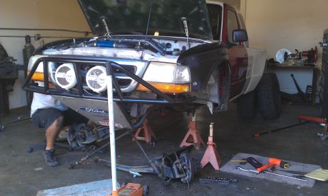1992 Ford Ranger - A Ford Ranger truck is undergoing mechanical work, with its front end lifted and components removed.