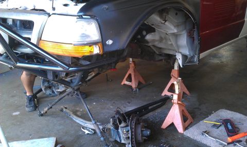 1992 Ford Ranger - Front end of a 1992 Ford Ranger undergoing work, a custom bumper and removed suspension components.