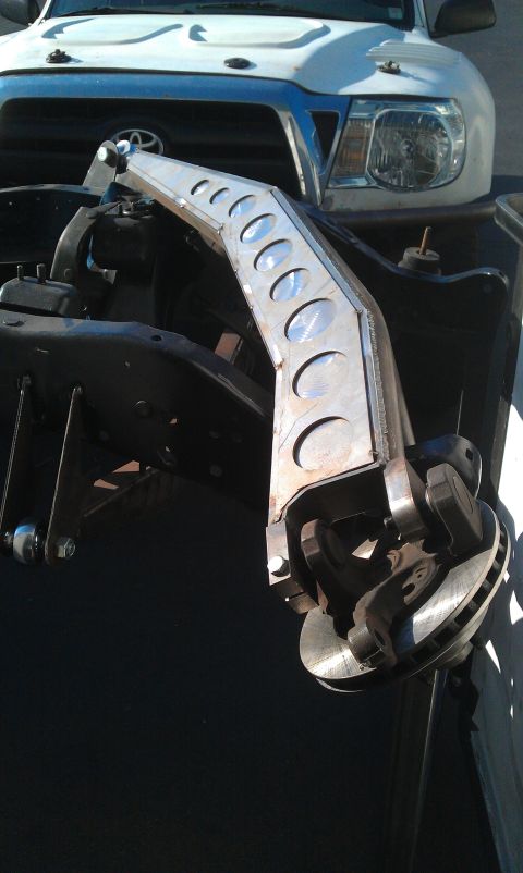 1992 Ford Ranger - A custom suspension component is mounted to the frame of a white Toyota Tacoma truck.