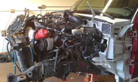1992 Ford Ranger - The engine bay of a truck is shown with its components exposed and disassembled.