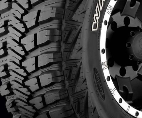 1995 Ford Bronco - A detailed view of an aggressive tire tread and a custom wheel, highlighting their construction.