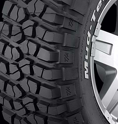1995 Ford Bronco - Close-up of a BFGoodrich Mud-Terrain T/A tire with aggressive tread pattern and a portion of a silver alloy wheel.