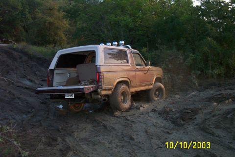 1982 Ford Bronco - This 1982 Ford Bronco navigates a challenging muddy incline with its tailgate open.