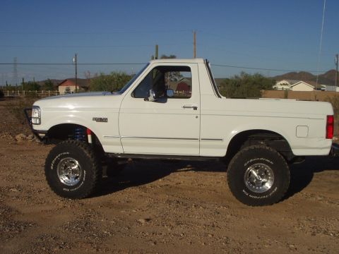 1993 Ford Bronco - White 1993 Ford Bronco lifted with off-road tires parked outdoors.