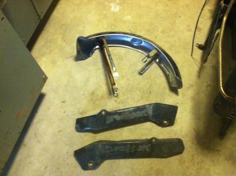 1981 Garelli Rally Sport - Parts from a motorcycle, including a fender and two side covers, are laid out on a concrete floor.
