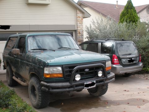 1996 Ford Bronco - 1996 Ford Bronco in front of a garage, with a Subaru Forester parked behind it.