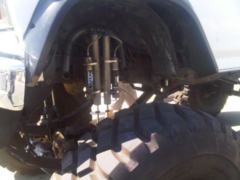 1986 Ford Bronco - This image focuses on the heavy-duty suspension system of a vehicle, prominent Fox shocks and tires.
