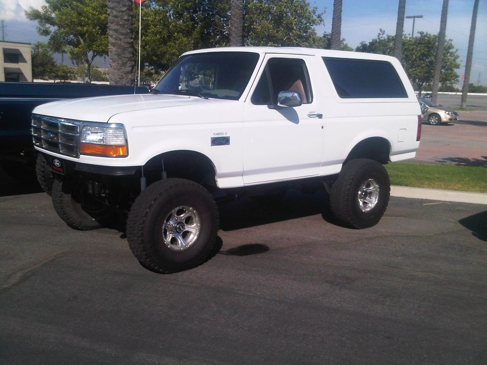 White lifted Ford Bronco with aftermarket wheels and tires