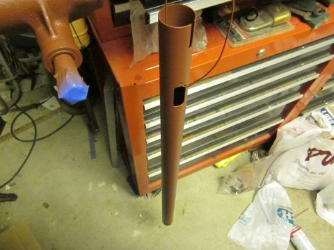 1979 Ford Bronco - A brown painted metal pipe hangs in front of a red toolbox, possibly during a restoration or repair process.