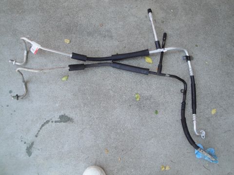 2003 Ford Taurus - AC hoses removed from a vehicle, laid out on concrete.