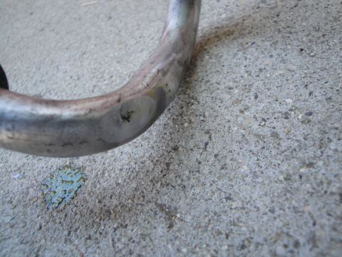2003 Ford Taurus - A close-up view of a damaged metal pipe on a concrete surface.