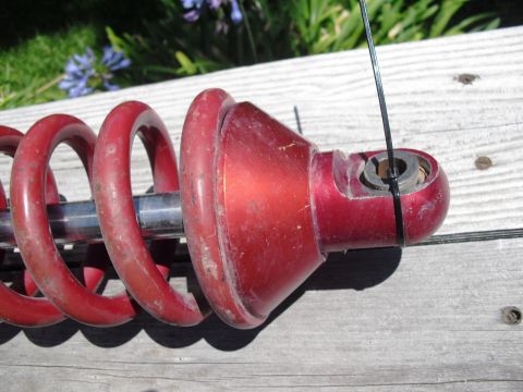 1986 Ford Bronco - Close-up of a red coilover shock absorber, likely an aftermarket part.