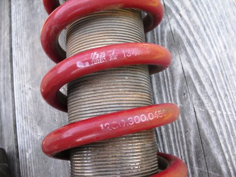 1986 Ford Bronco - Close-up of a red coilover shock absorber, showing part numbers and brand markings.