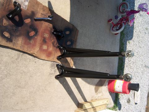 1996 Ford Bronco - Painted suspension control arms are laid out on cardboard and concrete, with a child's bicycle nearby.