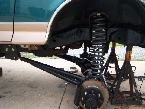 1996 Ford Bronco - The vehicle's suspension system is elevated on jack stands, its components during a modification.