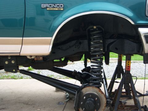 1996 Ford Bronco - The front suspension of a 1996 Ford Bronco is disassembled and supported by jack stands.