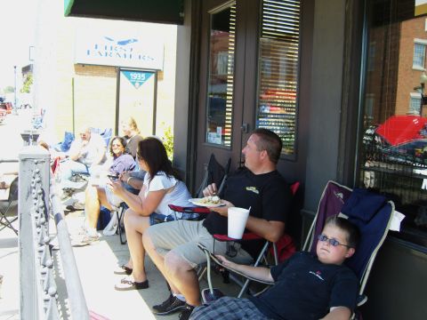 2007 Ford Mustang - Spectators relax on a porch, with a sign for 'First Farmers 1935' visible in the background.