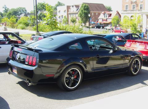2007 Ford Mustang - A black 2007 Ford Mustang is parked in a lot with other vehicles visible.
