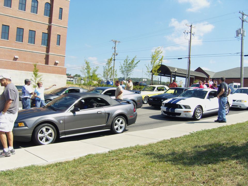 Gray 2007 Ford Mustang convertible parked on street with other Mustangs