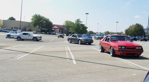 2007 Ford Mustang - A red 1987 Ford Mustang is parked in a lot with other vehicles.