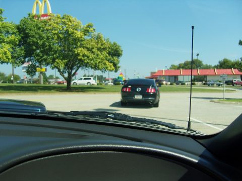 2007 Ford Mustang - Rear view of a black 2007 Ford Mustang parked in a lot with a McDonald's in the background.