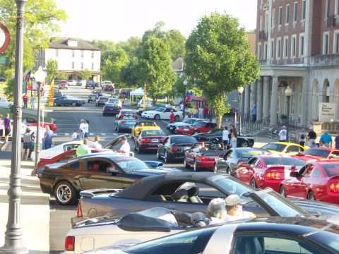 2007 Ford Mustang - A street filled with Ford Mustangs, likely at a car show or meet-up event.