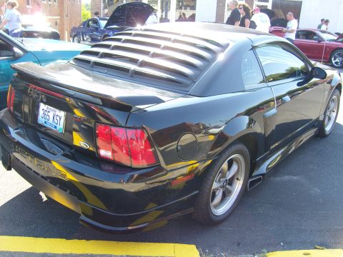 2007 Ford Mustang - A black Ford Mustang is parked at an outdoor event, with other vehicles visible in the background.