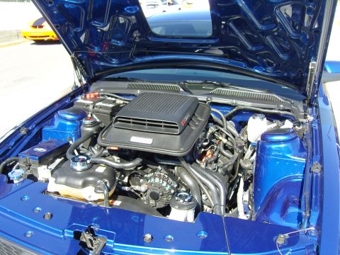 2007 Ford Mustang - Engine bay of a blue 2007 Ford Mustang, showing the V8 engine and intake system.