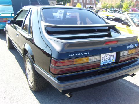 2007 Ford Mustang - Rear view of a black Ford Mustang SVO parked outdoors with other vehicles.