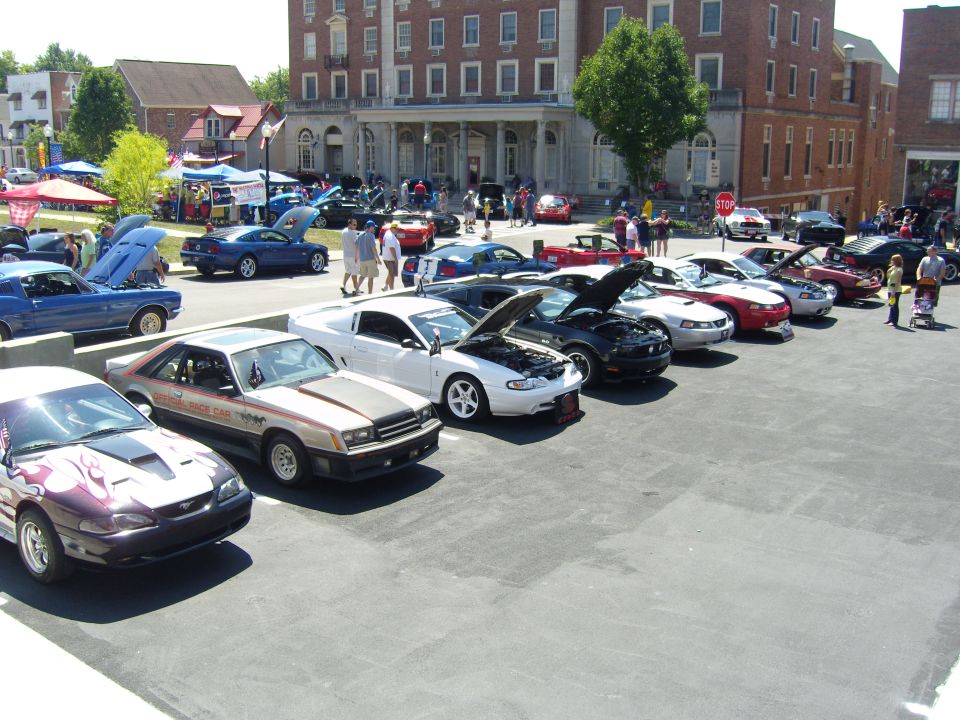 Row of Mustangs, one with flame graphics, another from the early 80s