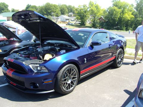 2007 Ford Mustang - A blue 2010 Ford Mustang GT500 is displayed with its hood open, revealing the engine and red racing stripes.
