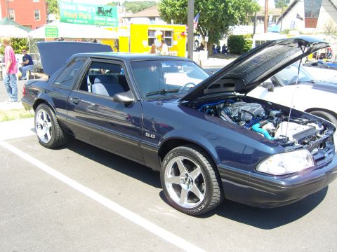 2007 Ford Mustang - A dark blue coupe with its hood open, revealing the engine bay and a '5.0' badge on the fender.