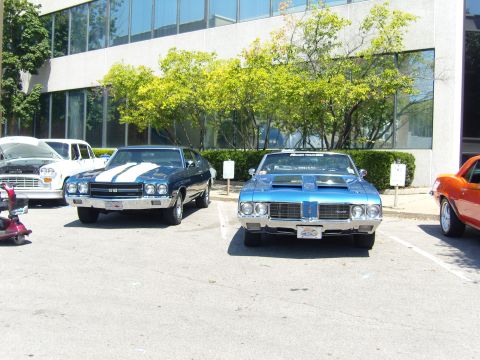 2007 Ford Mustang - A blue muscle car with white racing stripes is parked in a lot, with other vehicles visible.