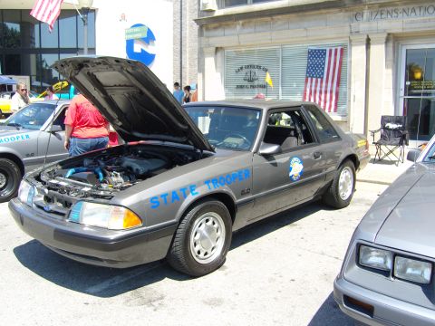 2007 Ford Mustang - A Ford Mustang modified as a state trooper vehicle is displayed with its hood open.