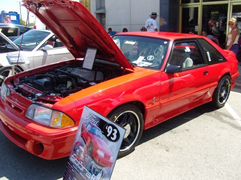 2007 Ford Mustang - Red 1993 Ford Mustang Cobra on display with its hood open, parked at an outdoor event.