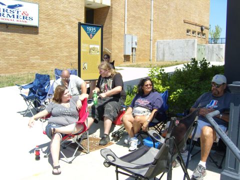2007 Ford Mustang - A group of people relax in lawn chairs on a sunny day, with a historical marker and bank sign in the background.