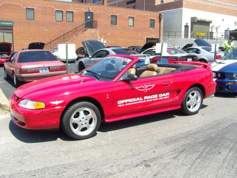 2007 Ford Mustang - A red convertible Mustang is parked at an outdoor event with other cars visible.
