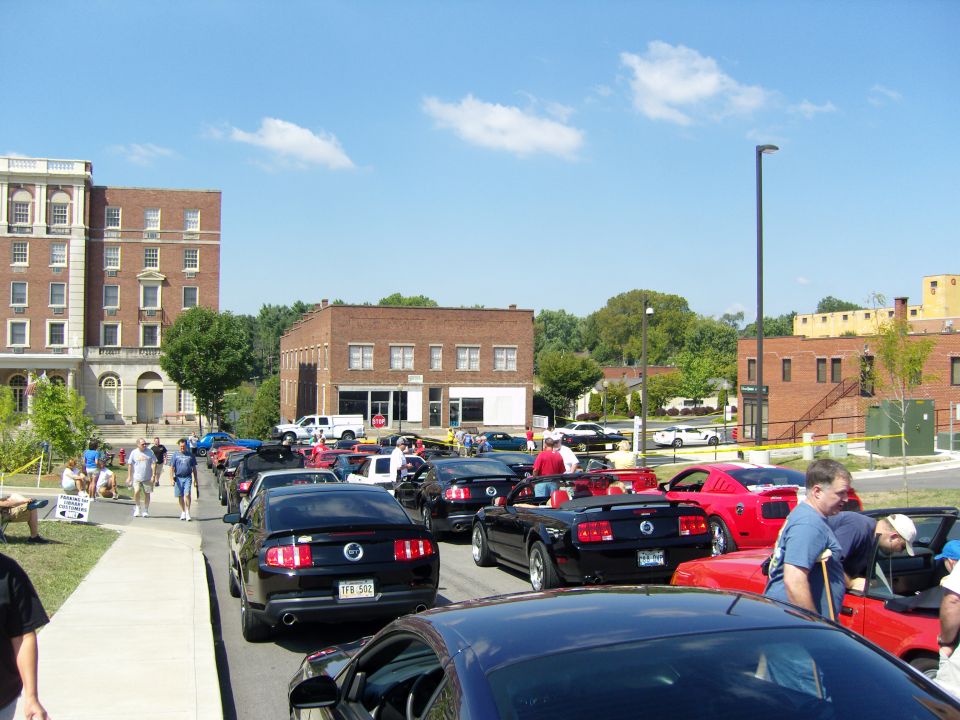 Rear view of black Ford Mustang with license plate VFB 542, part of a car show
