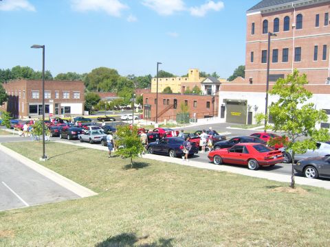 2007 Ford Mustang - A gathering of Ford Mustangs and other vehicles parked on a sunny day.