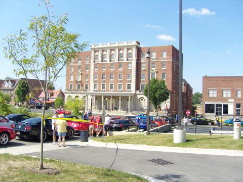 2007 Ford Mustang - Several Ford Mustangs are parked in front of a large brick building.