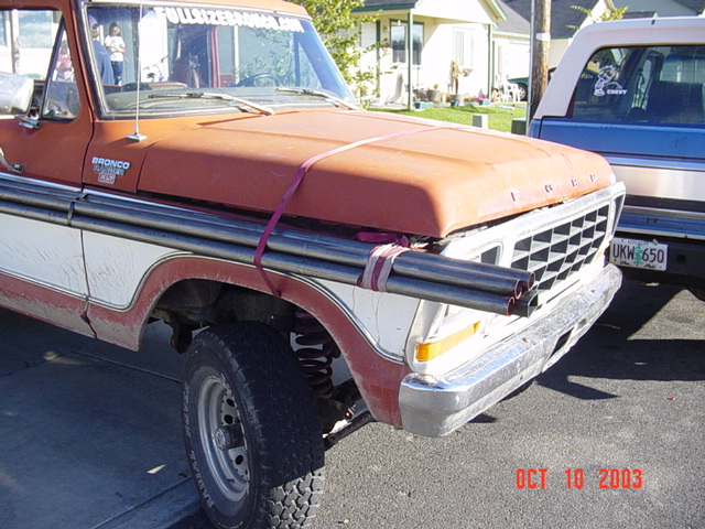 Orange and white 1978-79 Ford Bronco front with FORD-stamped hood and exhaust pipes strapped on, Oct 2003
