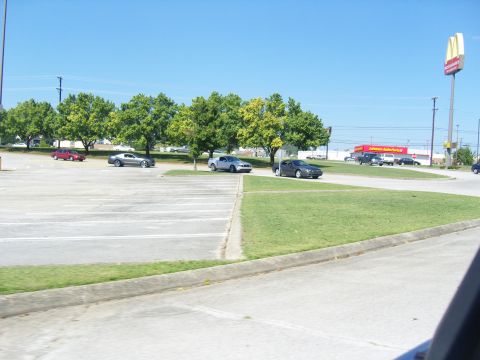 2007 Ford Mustang - A view of a parking lot with several vehicles, trees, and a McDonald's sign visible on a clear day.