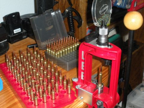 1996 Ford Bronco - A reloading press and trays full of cartridges are set up on a wooden surface.