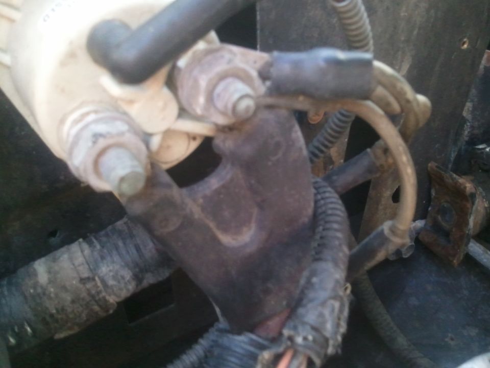 Close-up of engine part with electrical connectors and hoses