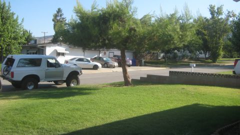 1996 Ford Bronco - This white Ford Bronco is parked curbside with a bicycle attached to its rear carrier.