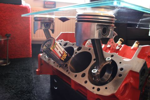 1973 Ford Ranchero - A coffee table constructed from an engine block with pistons and connecting rods supporting a glass top.