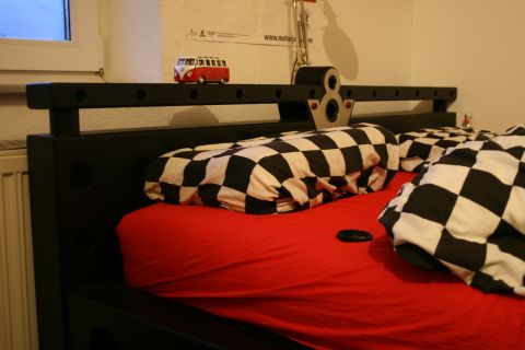 1973 Ford Ranchero - A toy van sits on a shelf above a bed with racing-themed checkered bedding.